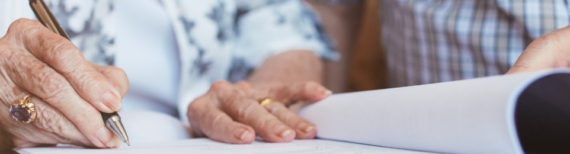 Elderly couple signing paperwork | Featured Image for What to Do With an Inheritance Blog by Approved Finance.