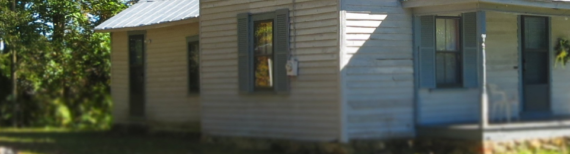 Photo of a small wooden farm house.